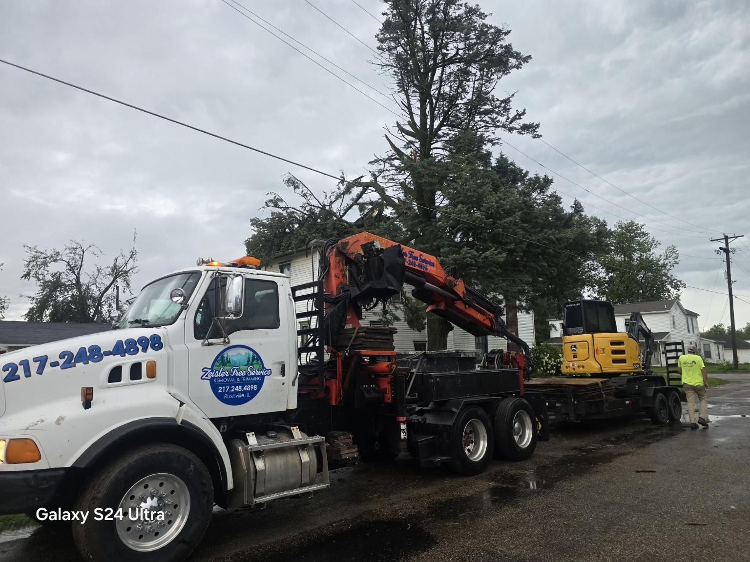 Zeisler Tree Service crane truck and John Deere excavator positioned at a removal job