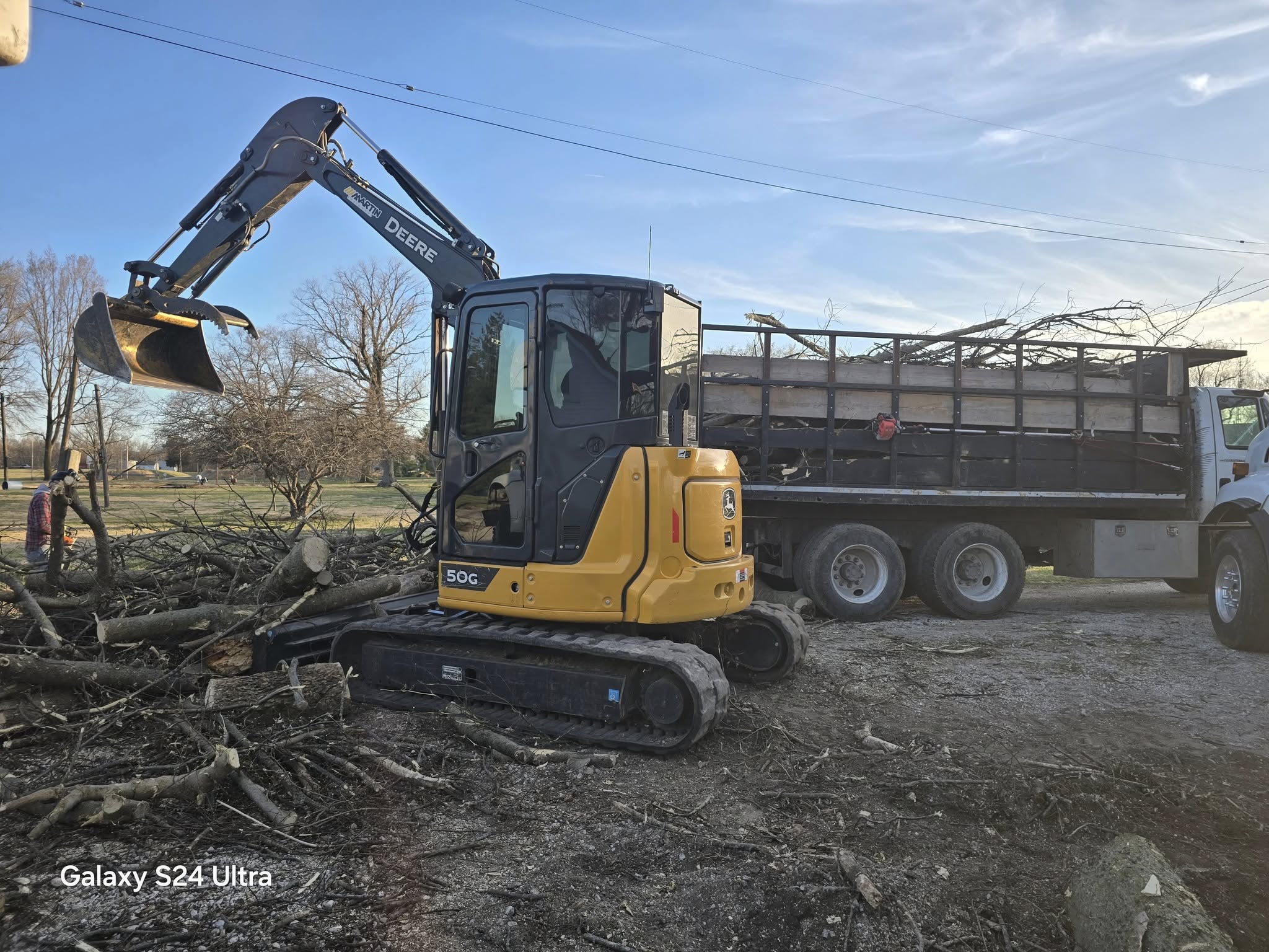 John Deere excavator beside a dump truck